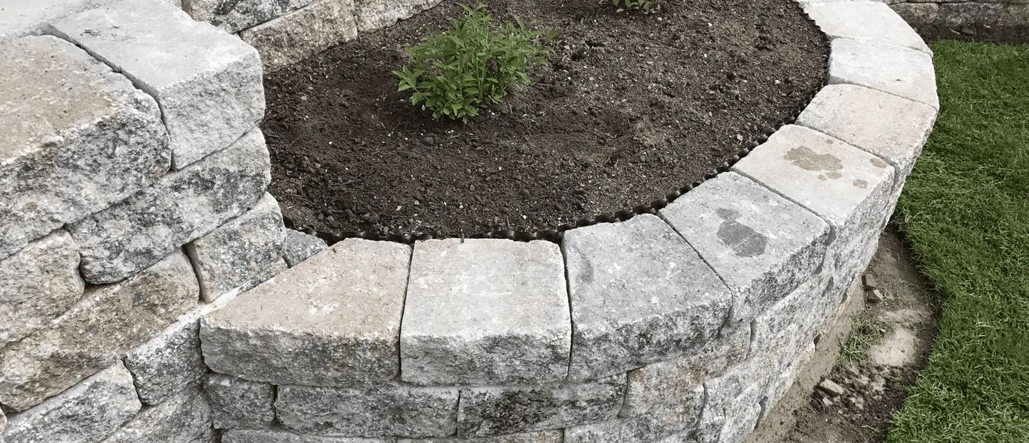 Stützmauer aus Naturstein rund um ein Beet
