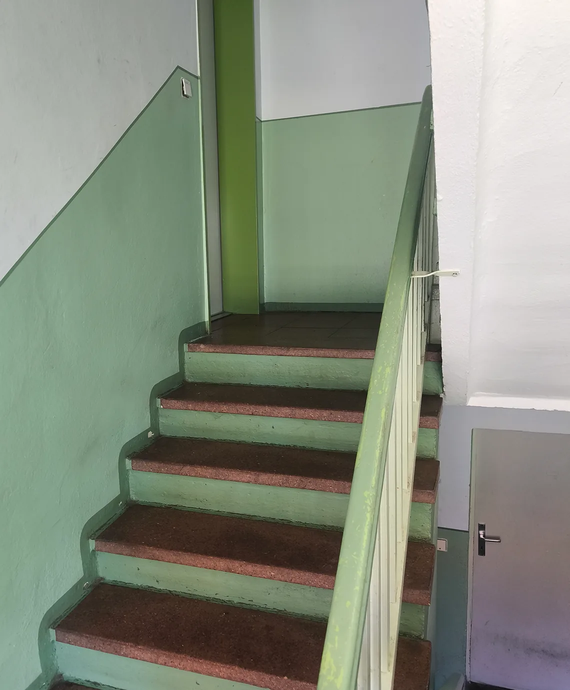 Treppenhaus mit grünem Altanstrich vor der Renovierung